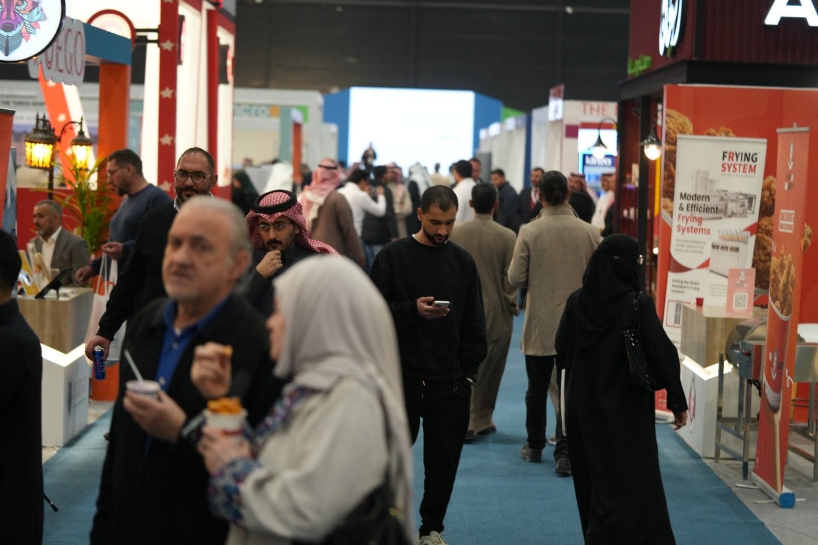 A busy exhibition aisle with visitors moving between supplier stands